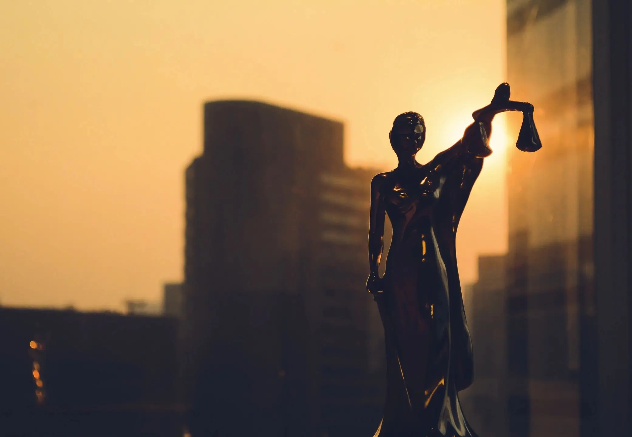 Silhouette of scales statue at sunset