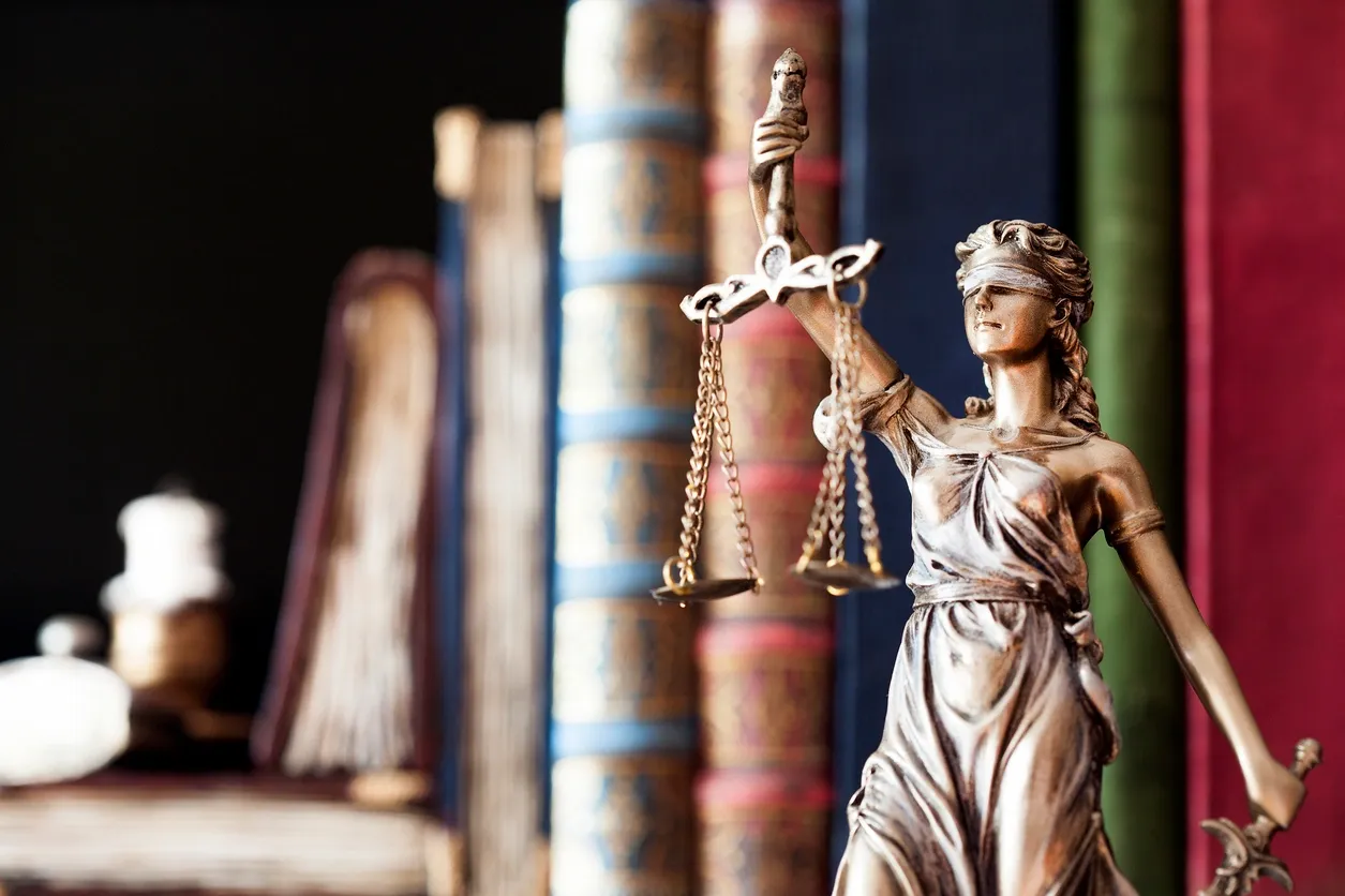 Blindfolded justice figure and law books